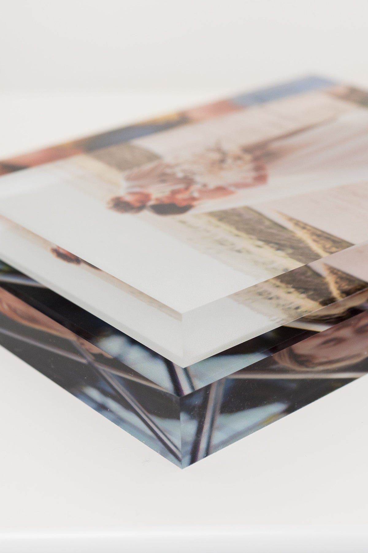 Close-up stack of clear acrylic photo display blocks with glossy printed faces