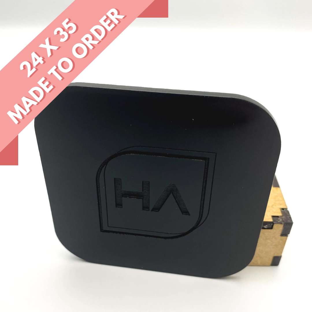 Glossy black acrylic sheet with etched HA logo, angled view of rounded square