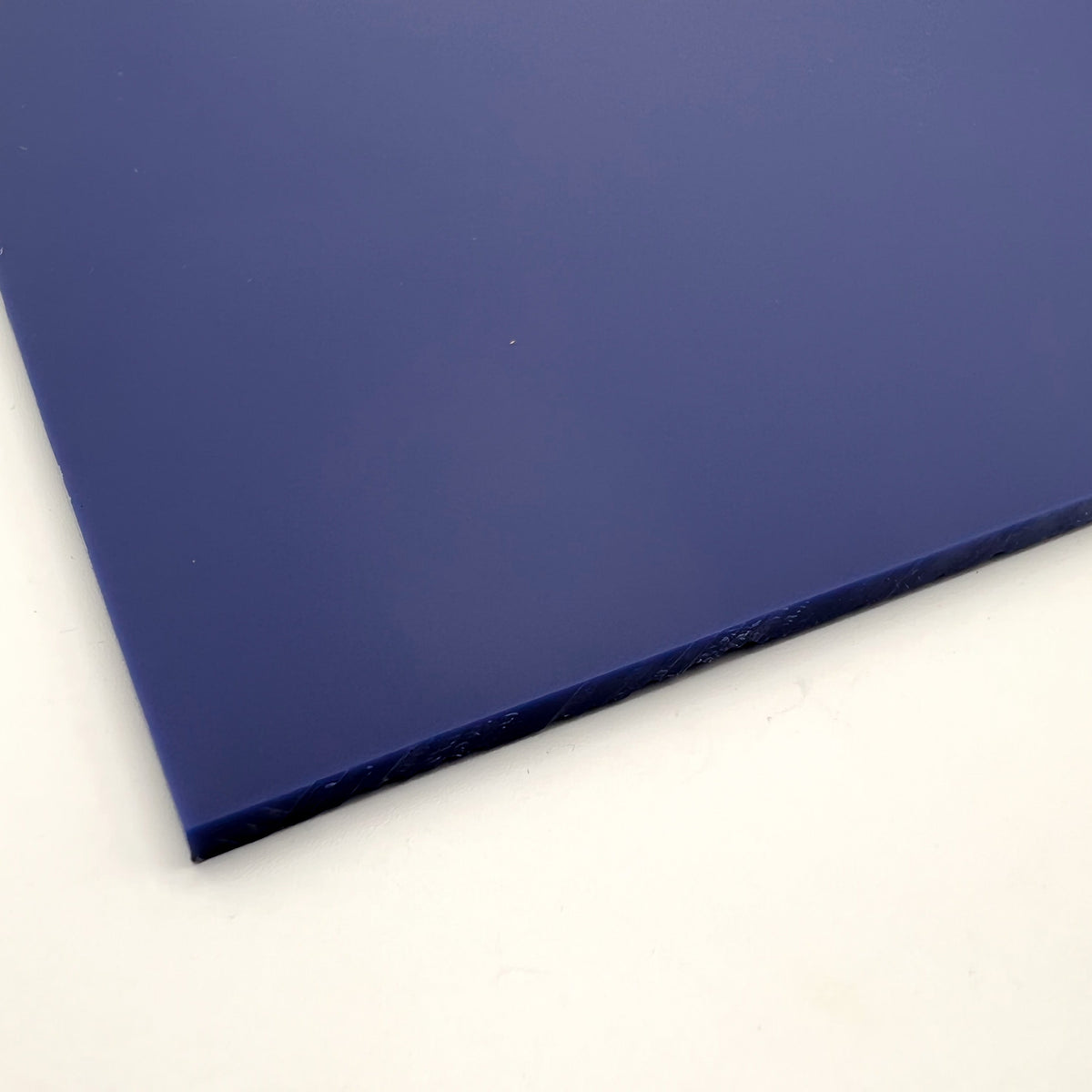Navy blue matte acrylic sheet corner close-up with smooth edge