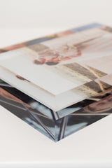 Close-up stack of clear acrylic photo display blocks with glossy printed faces