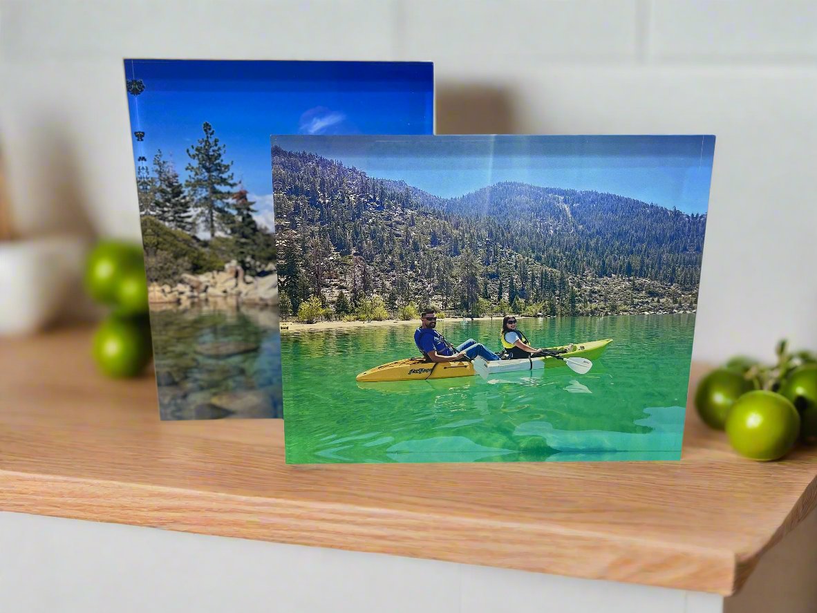 Clear acrylic photo display blocks with outdoor images, set on wood tabletop