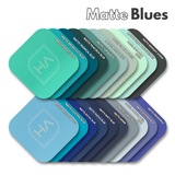 Assorted matte blue cast acrylic sample swatches in navy, teal, and pastel shades