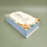 Light blue rigid magnetic closure gift box with hinged lid, floral print on top.
