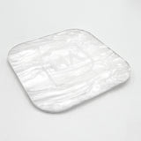 Pearl-finish white acrylic sheet sample, rounded square piece with glossy swirls