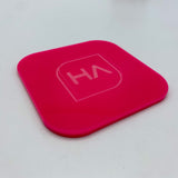 Hot pink glossy acrylic panel with embossed HA logo, rounded square corners