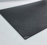 Black glitter acrylic sheet corner close-up, dark sparkling texture on edge