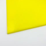 Fluorescent neon yellow cast acrylic sheet close-up, smooth glossy finish