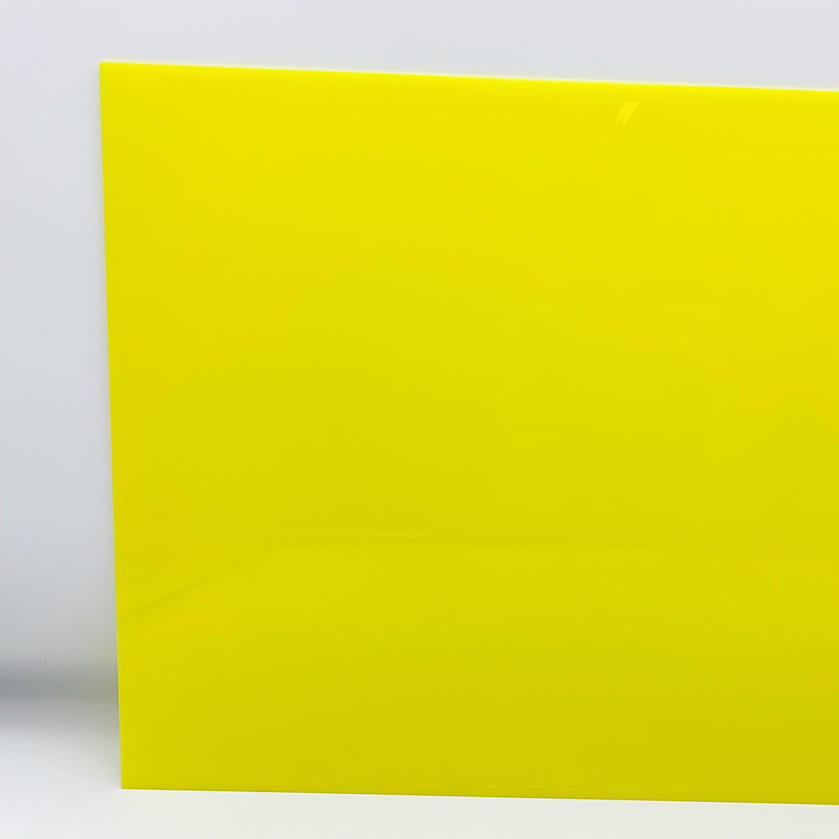 Fluorescent neon yellow cast acrylic sheet corner view, smooth glossy surface