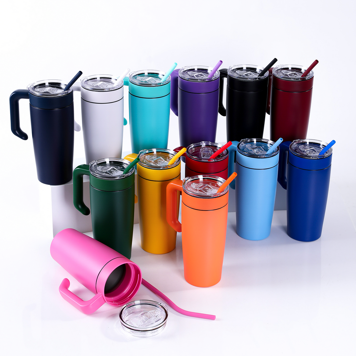 Group of colored 20oz stainless tumblers with clear lids and straws